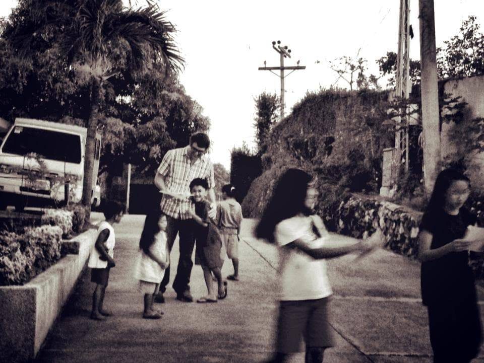 Man hugging children on the street.
