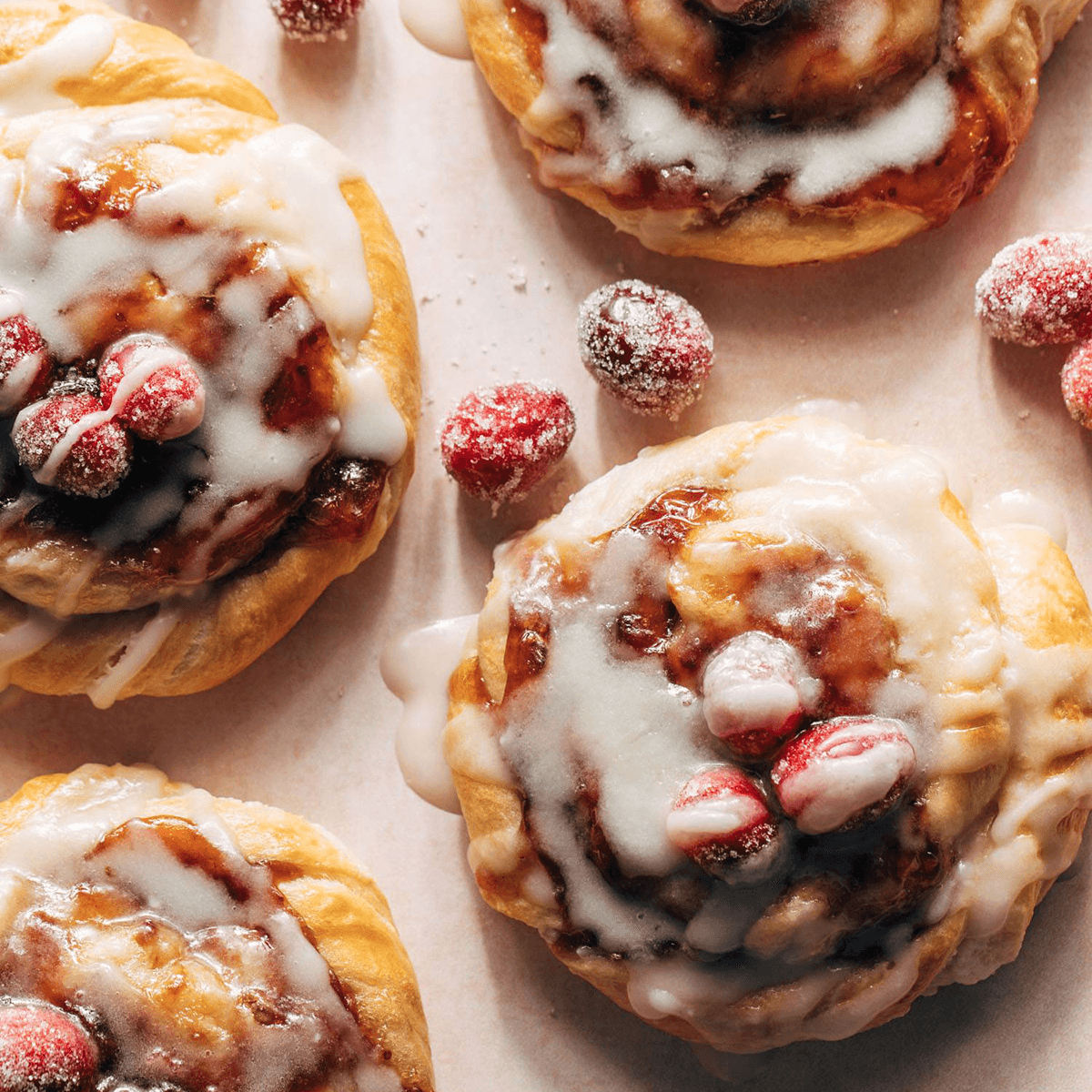 Cream cheese danishes with a glaze and sugared cranberries.