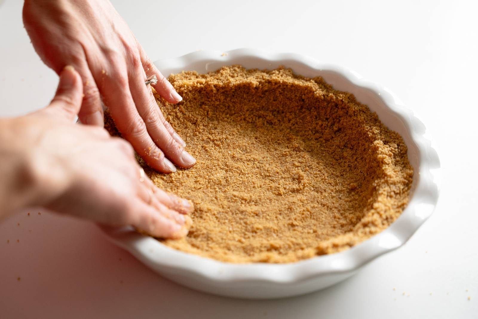 Forming graham cracker crust in pie plate.