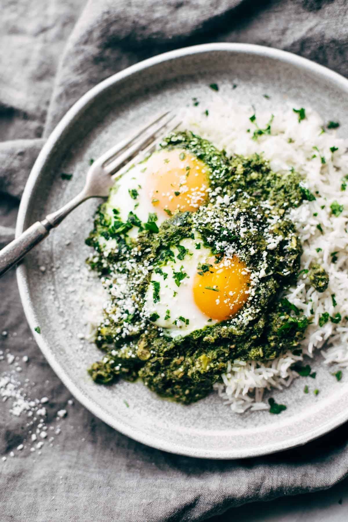 plate on a napkin with green shakshuka and eggs with a fork