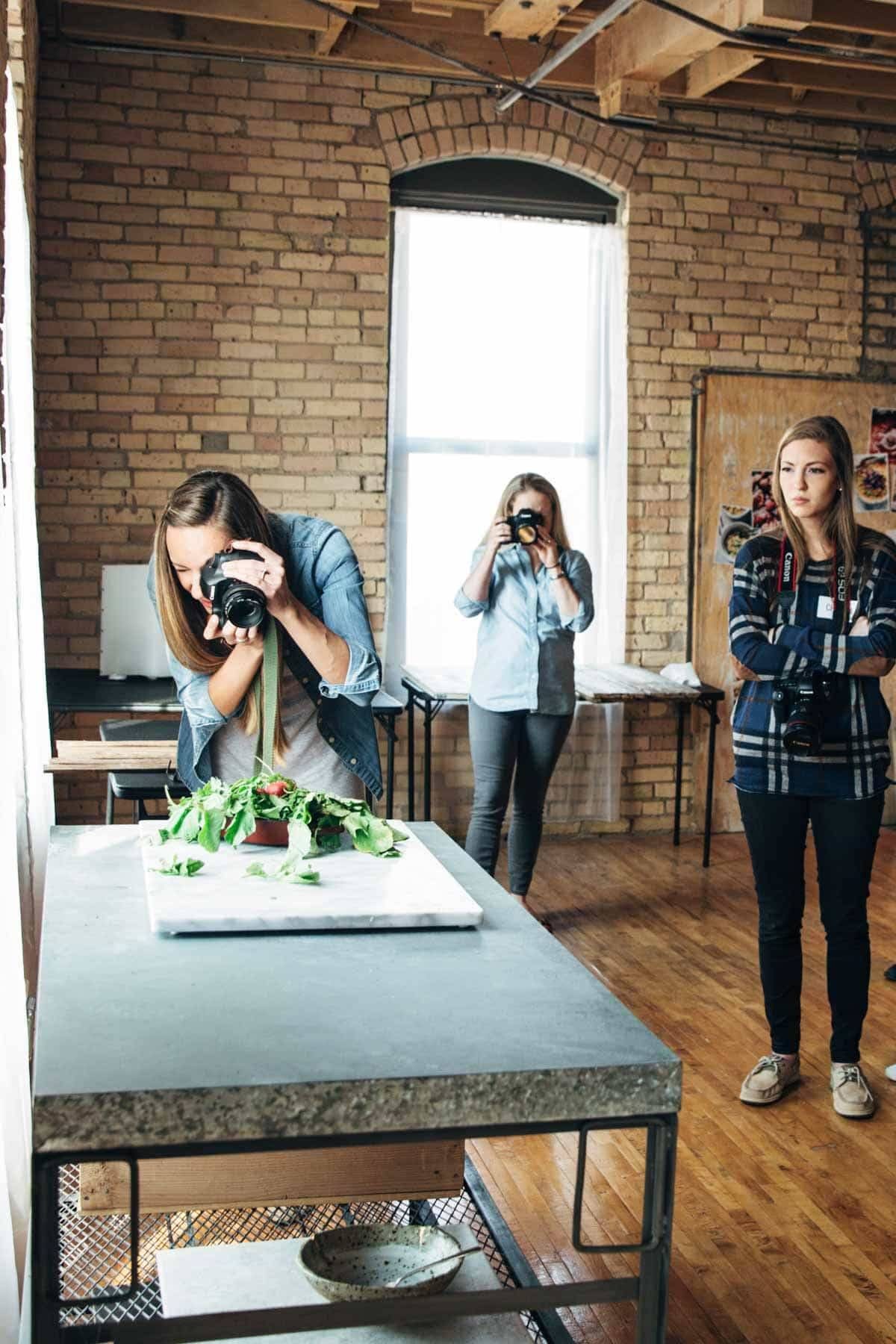 Woman taking a photo of food with a camera.